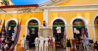 Prédio amarelo com arcadas e lojas de roupas e artesanato no Centro Histórico de São Luís